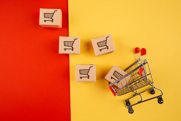 Paper brown boxes and trolley isolate on colorful background. The concept of delivery of goods from the online store to the house - Photo, Image
