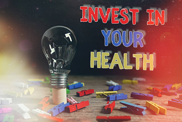 Conceptual hand writing showing Invest In Your Health. Business photo text put money on maintenance or improvement of your health Realistic colored vintage light bulbs, idea sign solution. - Photo, Image
