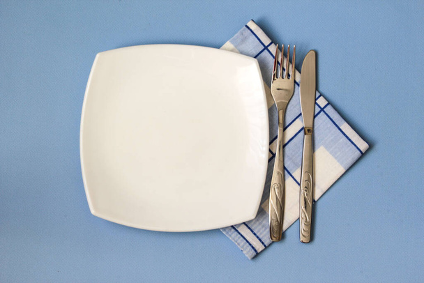 Table setting. Empty plate, knife, fork and napkin. Top view and flat lay with copy space - Фото, зображення