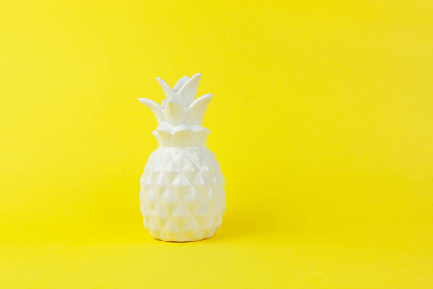 Trendy piece of interior white glossy ceramic pineapple on yellow paper background, copy space. Minimal style of decor concept. Horizontal. For lifestyle, interior blog, social media, poster. - Fotoğraf, Görsel