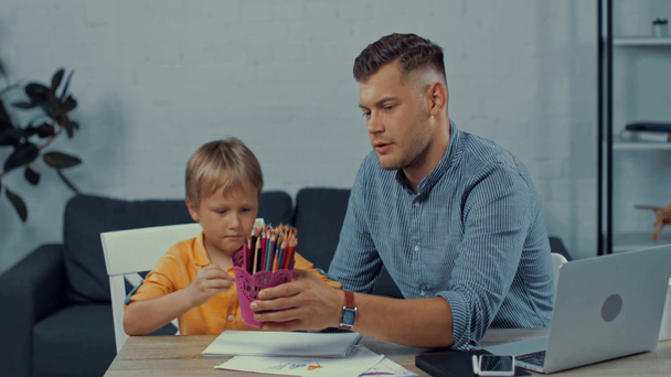 father and son drawing near gadgets on table - Footage, Video