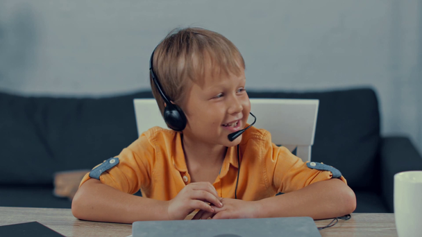 enfoque selectivo de niño feliz en auriculares hablando en casa
 - Metraje, vídeo