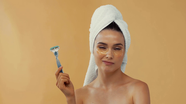 Ragazza nuda con asciugamano sulla testa lanciando rasoio isolato su beige - Filmati, video