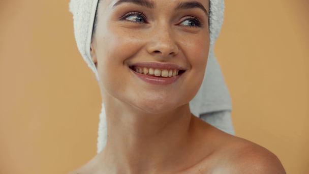 Beautiful naked woman with towel on head smiling at camera isolated on beige - Video, Çekim