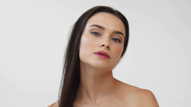 Schöne nackte Frau berührt Haare und lächelt isoliert auf grau - Filmmaterial, Video