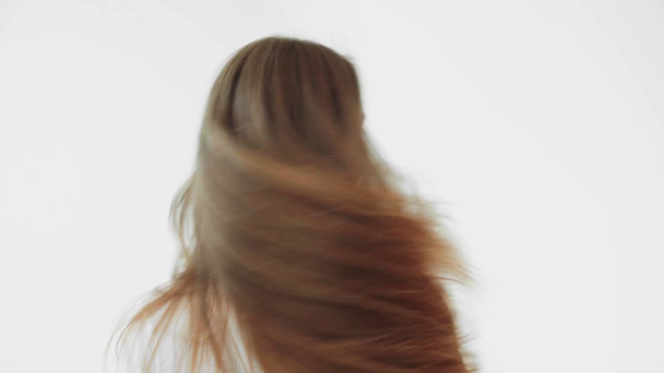 Vista posterior de la joven mujer sacudiendo la cabeza aislada en gris
 - Metraje, vídeo