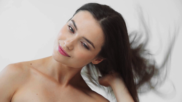 Krásná nahá dívka pomocí vysoušeče vlasů a usmívá izolované na šedé - Záběry, video
