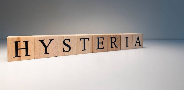 The word hysteria made of wooden cubes. Studio photo was taken in spot light. In white background. The term of interest in psychology and health. - Photo, Image