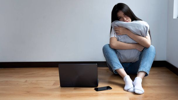 szomorú nő, aki egy párnára támaszkodik, mellette a laptopjával. a szomorúság fogalma. karantén, kovid-19 - Fotó, kép