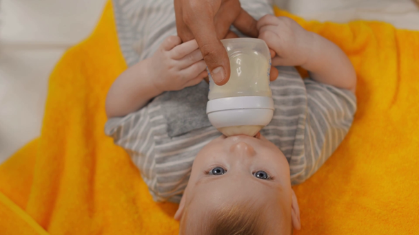 Ansicht von oben: Vater füttert niedlichen Säugling  - Filmmaterial, Video