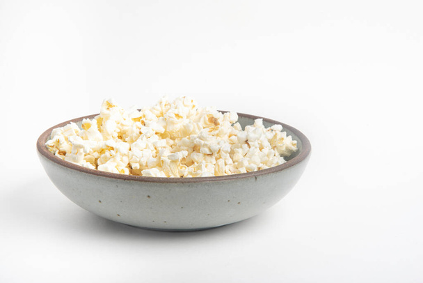 Popcorn w ceramicznej misce na białym tle. - Zdjęcie, obraz