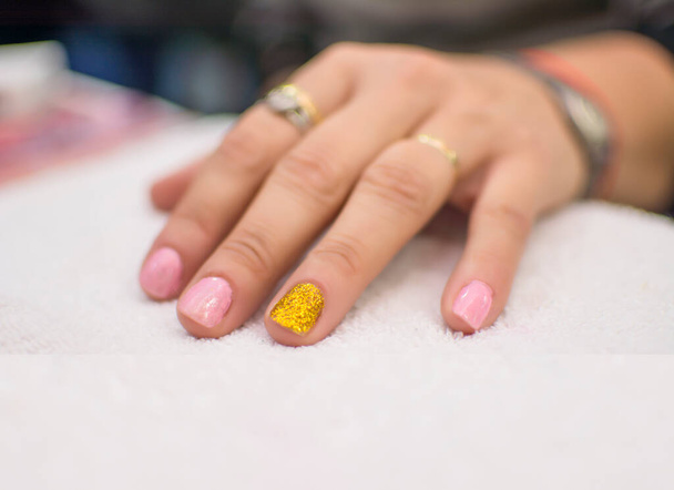 Beautiful semi-permanent manicure nails. Light manicure in light on a white background in a beauty salon - Фото, изображение