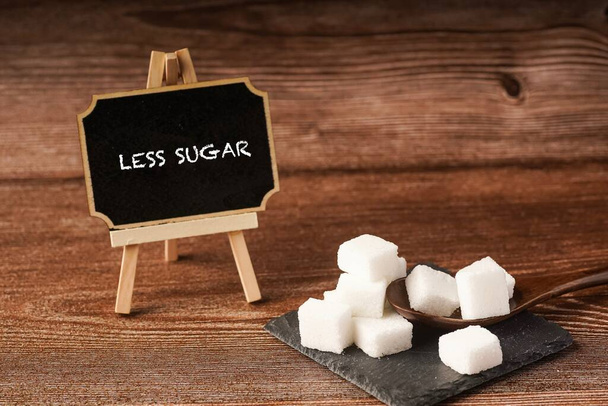 Kostki cukru z drewnianą łyżeczką. Koncepcja niezdrowego żywienia - Zdjęcie, obraz