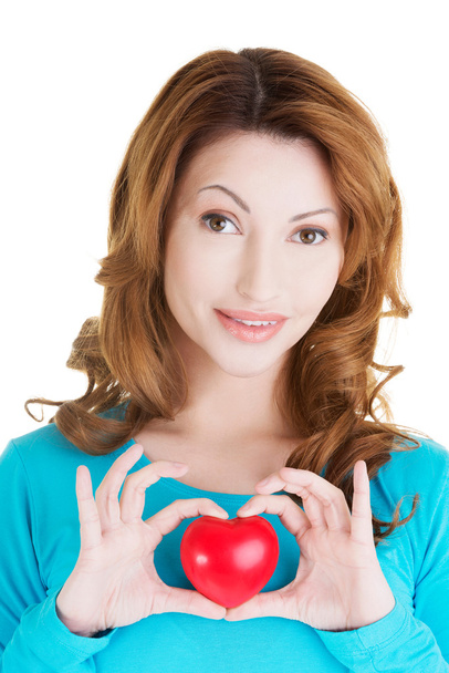 Attractive smiling woman showing red heart - Foto, Imagen