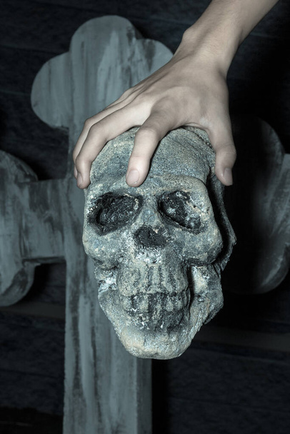 Рука держит череп на кладбище, эффект фильтра
. - Фото, изображение