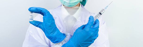 医師、科学者、研究者の手で青い手袋やヒト臨床注射試験のための保護スーツの準備ワクチン接種covid-19コロナウイルスワクチン接種生物学的危険概念 - 写真・画像
