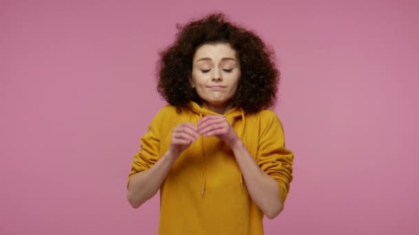 Lovely pretty girl afro hairstyle in hoodie sleeping on palms and smiling with pleasure expression, dreaming comfortable, taking nap resting during day. indoor studio shot isolated on pink background - Footage, Video