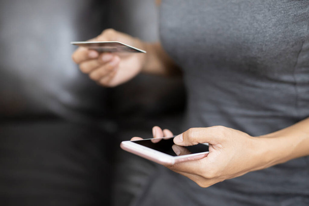 Mains de femmes jouant un téléphone intelligent, elle fait des achats en ligne via des cartes de crédit. Concepts commerciaux et technologiques. - Photo, image