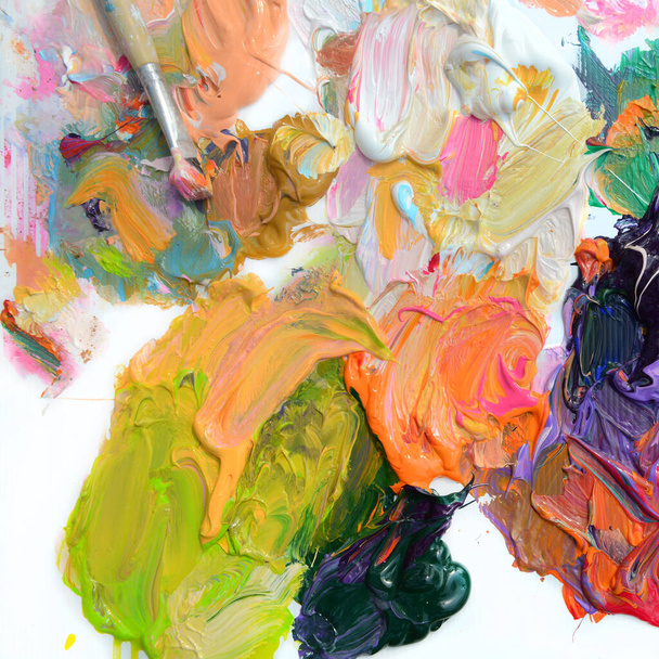 Peinture à l'huile colorée de différentes couleurs sur une palette et pinceaux sur fond blanc
 - Photo, image