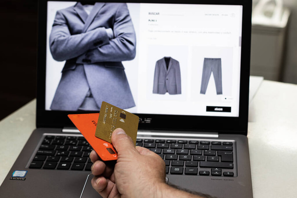 Adamın elinde kredi kartları var, bu da online mağazalarda ödeme aracı oluyor. İnternetteki elektronik ticaret ve çevrimiçi ödeme yöntemleriyle ilgili. İnternetten alışveriş - Fotoğraf, Görsel