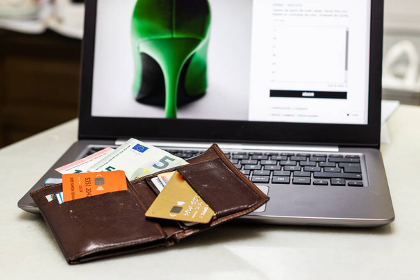 Online-Shopping ist derzeit weltweit am weitesten verbreitet. Brieftasche auf einem Computer mit Kreditkarten und Tickets, die in einem Online-Shop gekauft werden können. - Foto, Bild