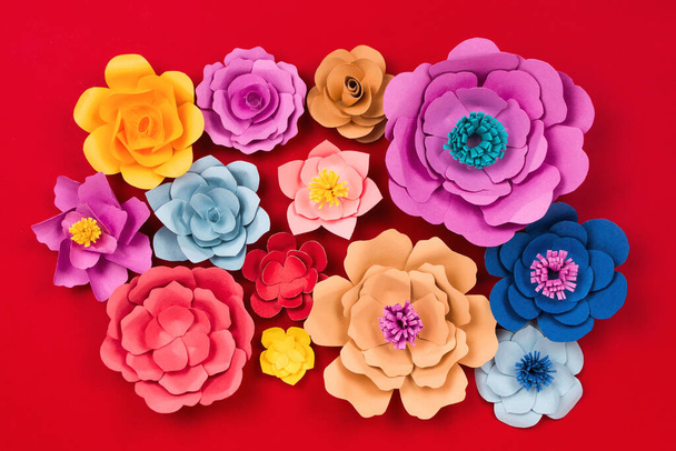Beautiful floral spring or summer background. Papercraft flowers on red background, top view, flat lay - Foto, immagini