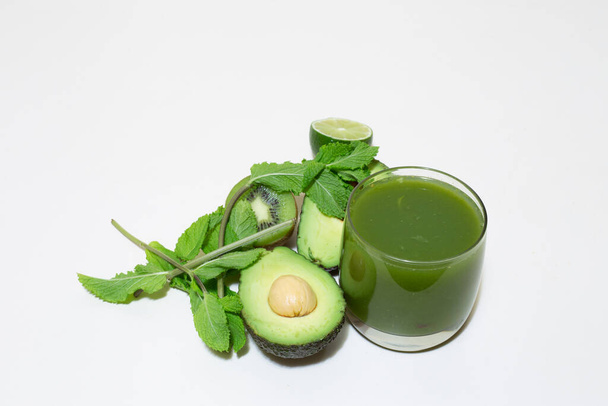 Green smoothie of avocado, lime, mint and kiwi. Healthy organic fruit drink rich in vitamins. Vegetarian natural refreshing cocktail. Raw superfood juice. Detox shake for diet full of nutrients - Фото, зображення