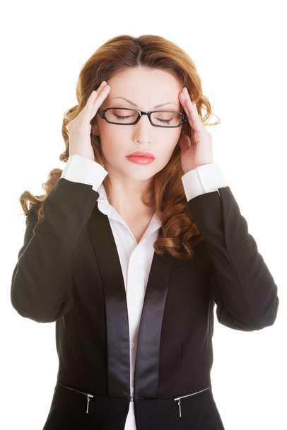 Mulher de negócios com uma cabeça de preensão de dor de cabeça
 - Foto, Imagem