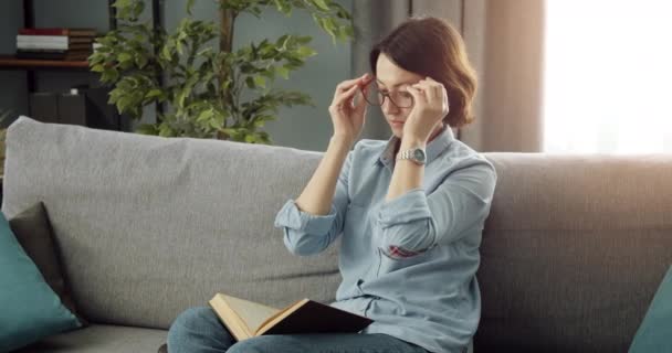 Mature lady reading new book in protective eyeglasses - Séquence, vidéo