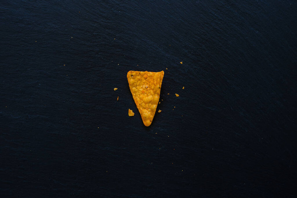 Fichas de nachos colocadas en el centro del fondo de la mesa con espacio para copiar. chips de tortilla hechas de maíz con sabor natural en la ranura de piedra oscura a
 - Foto, Imagen