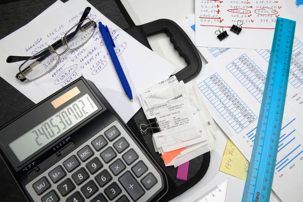 business office desk closeup - informes financieros, análisis y contabilidad, conjunto de documentos, tablas y gráficos, diversos elementos para contabilidad, calculadora - Foto, imagen