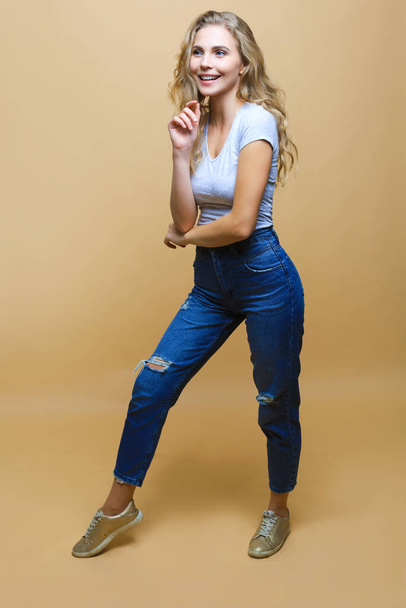 Full length photo of charming young woman in casual wear over beige background - Φωτογραφία, εικόνα