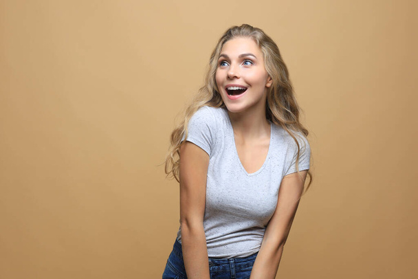 Portrait of young beautiful cheerful girl smiling looking at camera over beige background - Photo, image