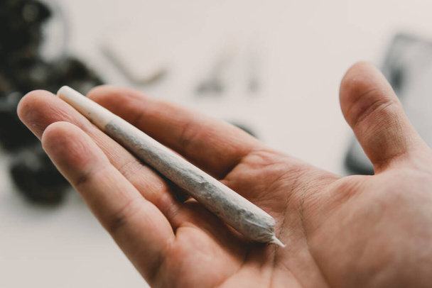 marijuana Rolling a marijuana joint. cannabis joint. Cannabis use concept. Preparing and rolling Close up of marijuana blunt with grinder. - Foto, afbeelding