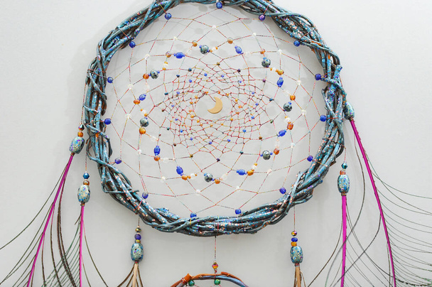 Closeup details modern dreamcatcher with natural peacock feathers on gray background - Photo, Image