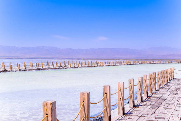 Sul vasto lago salato, ci sono lunghi marciapiedi di legno. Il bellissimo scenario di Chaka Salt Lake è in estate nella provincia di Qinghai, Cina. - Foto, immagini