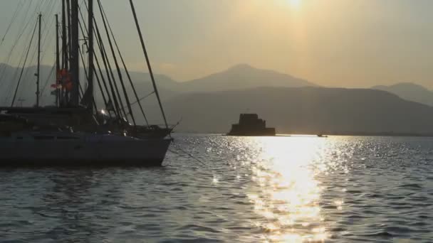 Чудовий захід сонця в Греції. З плавучими човнами, блакитною водою і гарними краєвидами.. - Кадри, відео