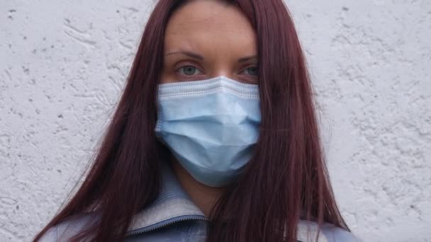 Πορτραίτο μιας γυναίκας με ιατρική μάσκα σε μια θυελλώδη μέρα. - Πλάνα, βίντεο