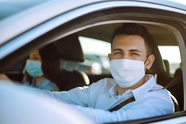 Man driving a car wearing on a medical mask during an epidemic, a driver- taxi in a mask. Covid-2019. - Fotoğraf, Görsel
