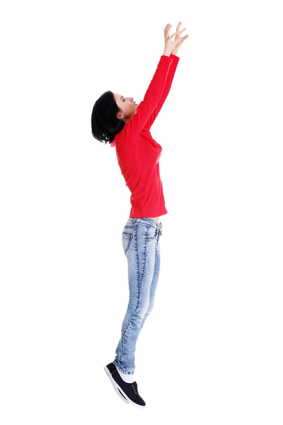 Teen girl jumping in air trying to catch something. - Φωτογραφία, εικόνα