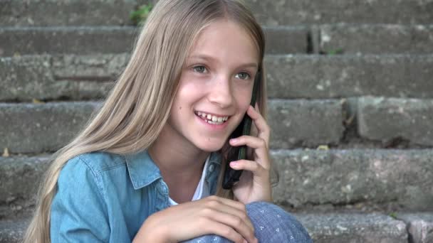 Kid Talking on Smartphone, Child Using Smart Phone, Teenager Blonde Girl Playing Outdoor in Park - Metraje, vídeo