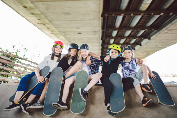 Extremsport in der Stadt. Skateboarding Club für Kinder. Gruppenfreunde posieren auf einer Rampe im Skatepark. Frühe Jugend im Skatetraining. Freunde Skateboarder auf Straßenplattform zum Skaten an Bord. - Foto, Bild