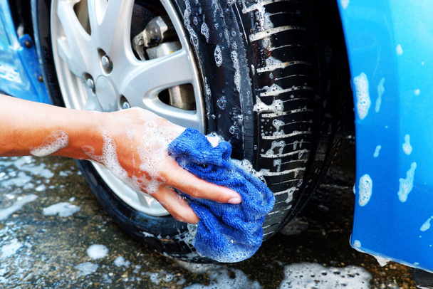 Cleaning the car wheels with microfiber cloth While washing the car - Foto, imagen