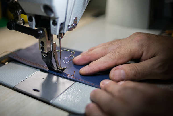 A man sews from leather on a sewing machine. Hands and sewing.  - Φωτογραφία, εικόνα