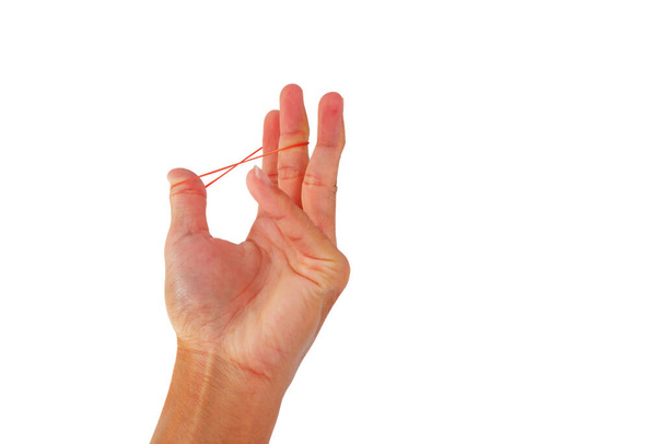 Faixa de borracha de plástico na mão com exercício de dedo no fundo branco
 - Foto, Imagem