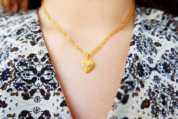 arany nyaklánc és szív alakú arany medál a nyakán ázsiai nő. - Fotó, kép