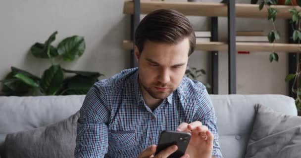 Man holding cellphone feels happy by news in received sms - Кадры, видео