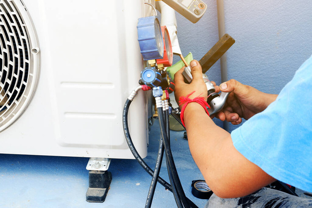 Airconditioning Technicus is Repareren airconditioner, Vanwege lekkage van luchtoplossing bij de pijp gezamenlijke - Foto, afbeelding