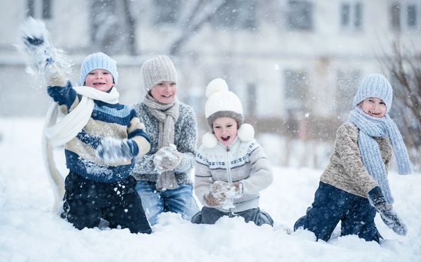 Children playing in the snow on a winter day - Фото, изображение