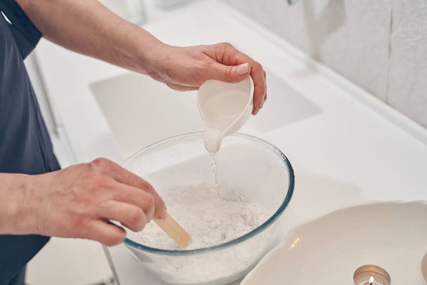 Preparing kaolin clay for beauty procedures in spa salon - Valokuva, kuva